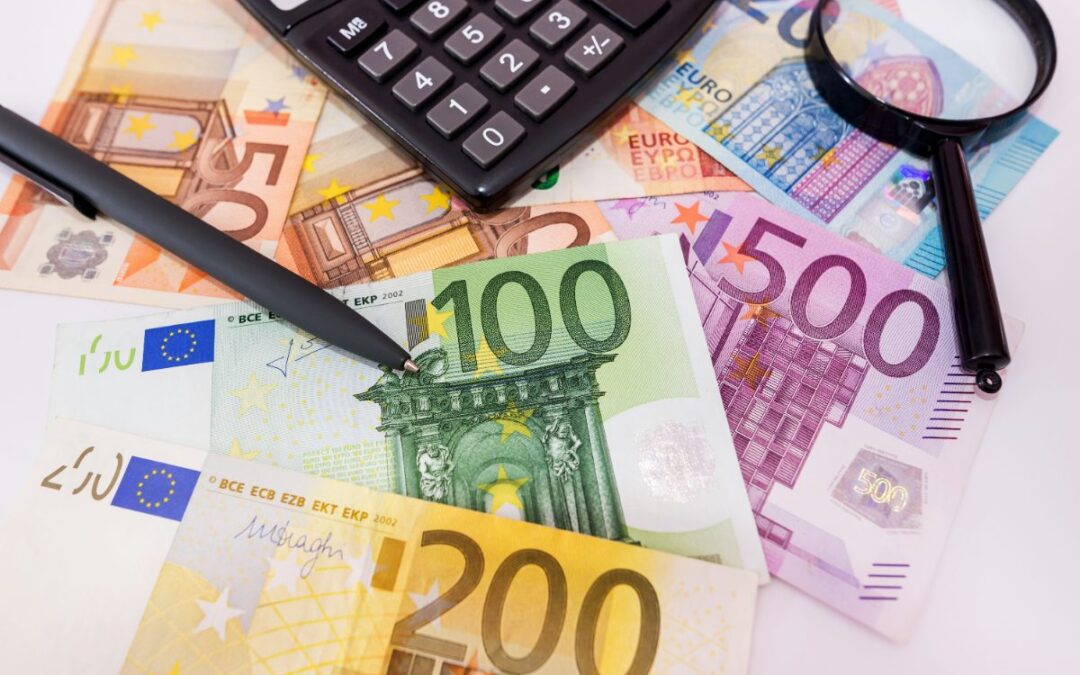 billetes de euro, calculadora y lupa, cuánto cuesta un seguro de decesos