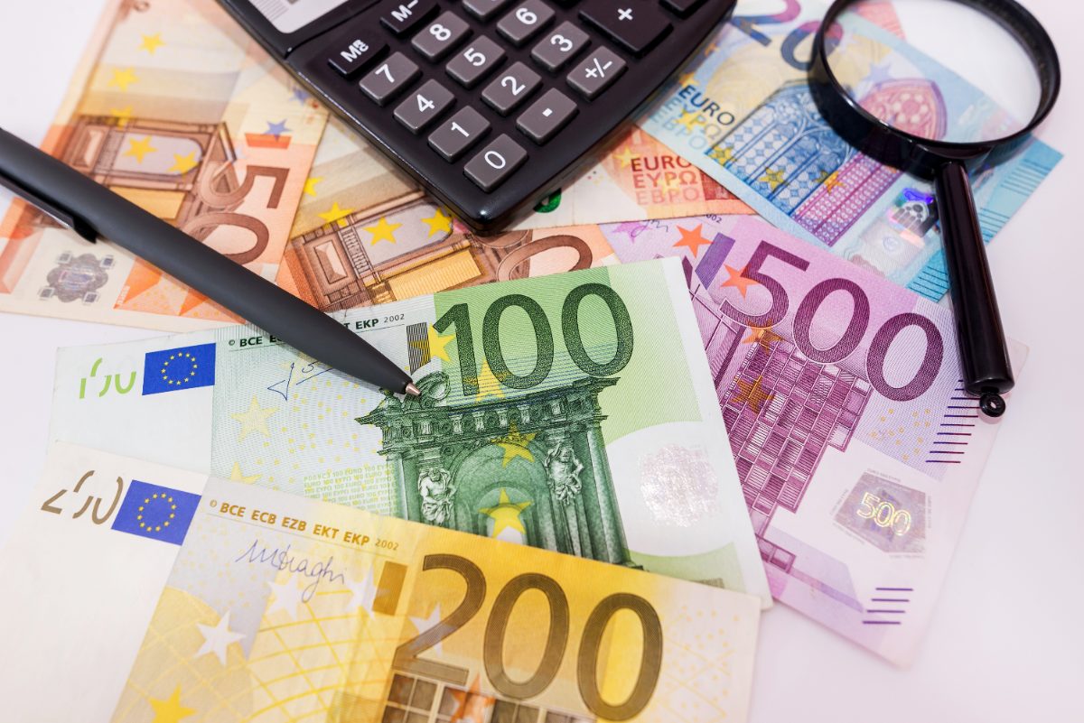 billetes de euro, calculadora y lupa, cuánto cuesta un seguro de decesos