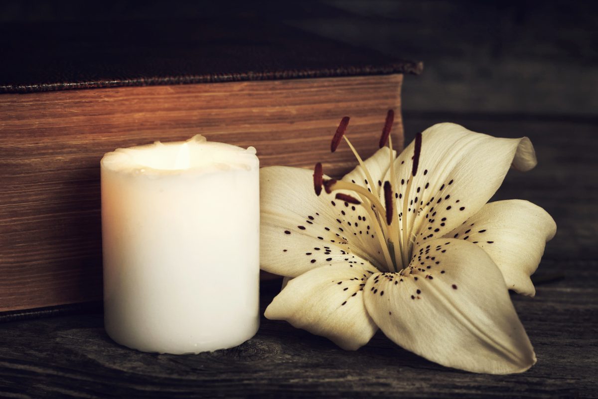 vela blanca y flor de lirio de condolencia, qué es un seguro de decesos guía completa