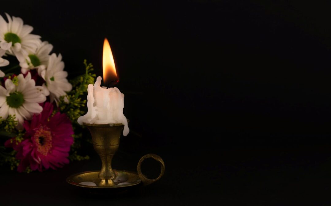 Entierro o cremación: vela encendida entre flores