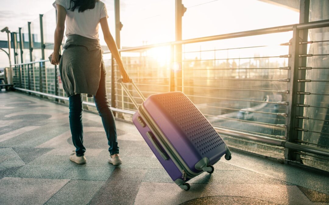Asistencia en viaje del seguro de decesos: viajera con maleta en el aeropuerto