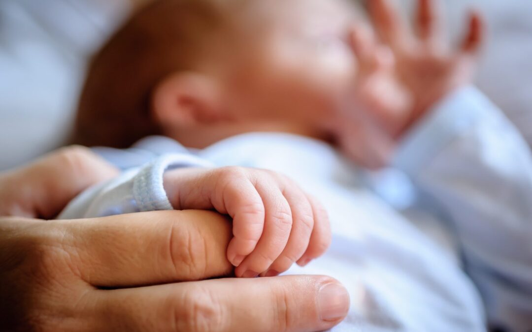 Seguro de decesos para niños y bebés: bebé agarrando el dedo de su madre