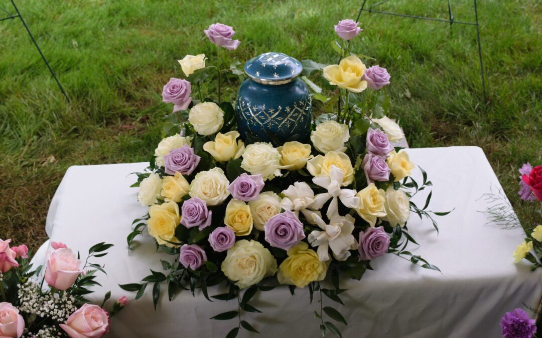 Flores y coronas rodeando una urna funeraria