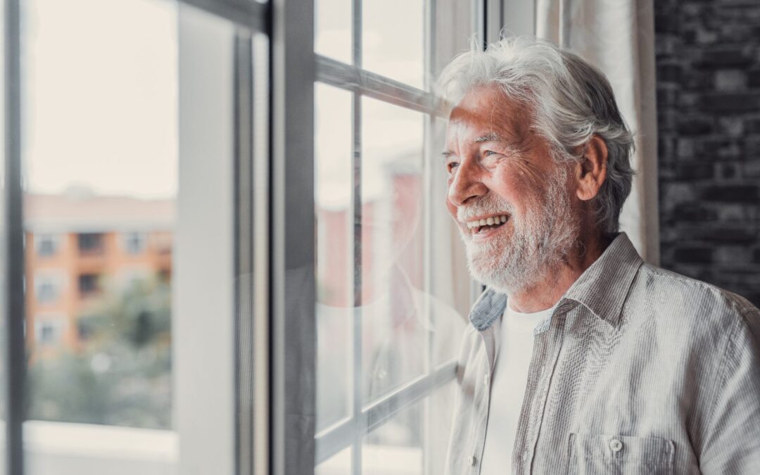 Hombre mayor pensativo junto a la ventana: límites de edad del seguro de decesos