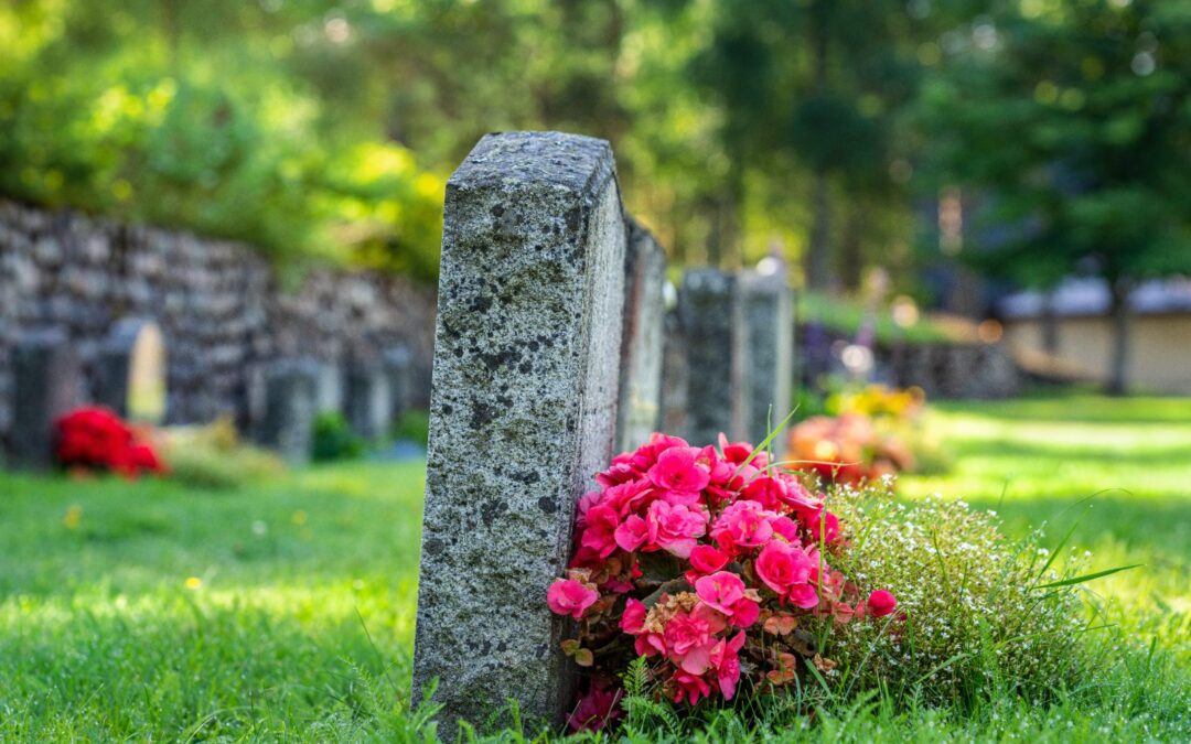 Hilera de lápidas con flores: tasas del cementerio y mantenimiento del nicho